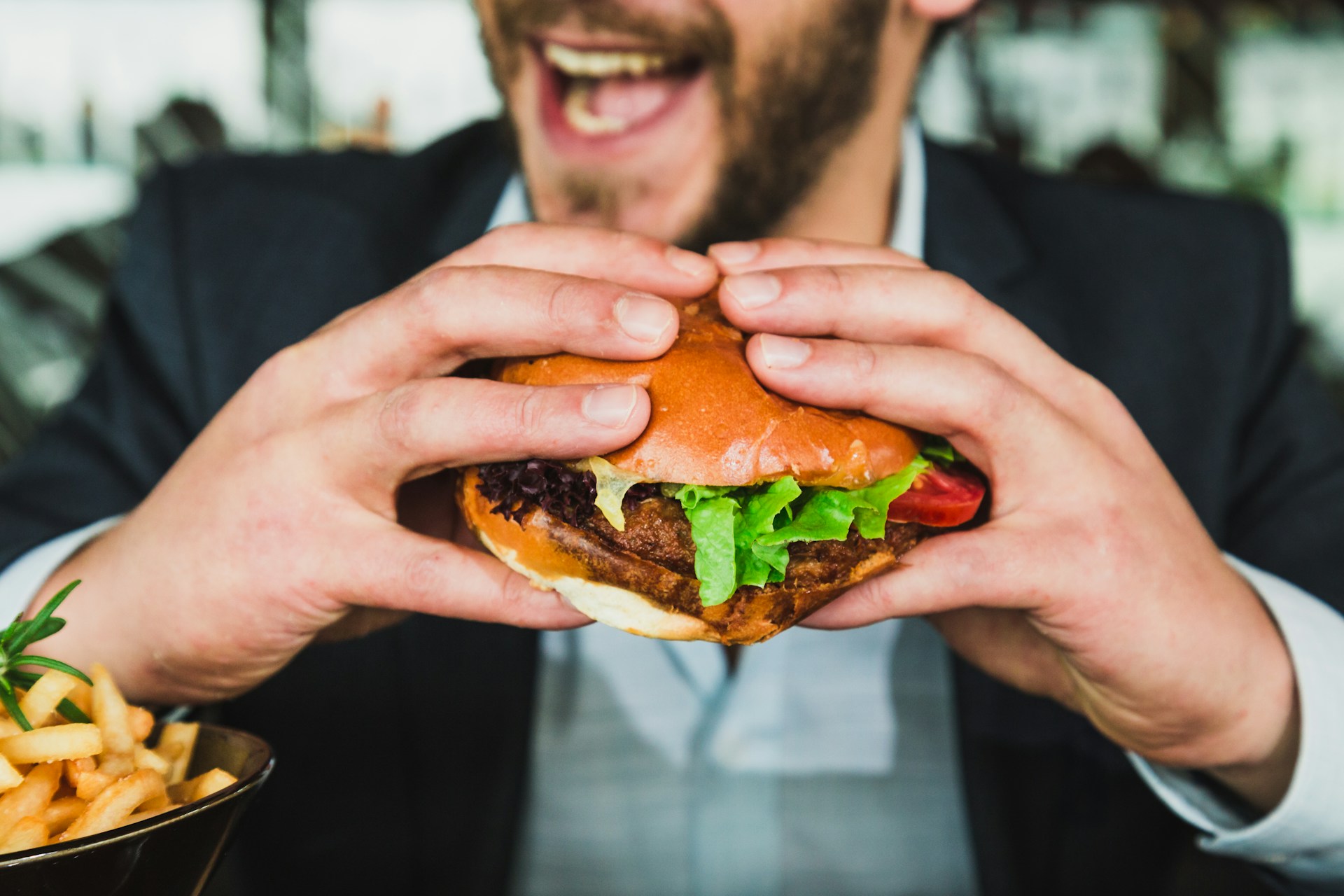 Man holding a hamburger. Photo: Sander Dalhuisen/Unsplash